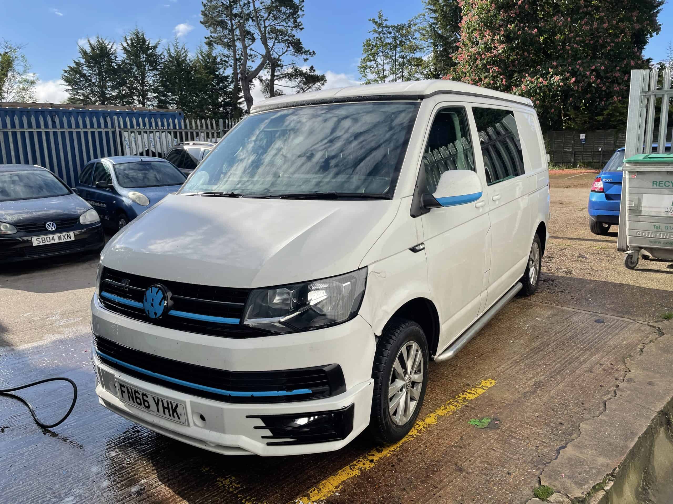 White van undergoing repair at a car accident repair shop.